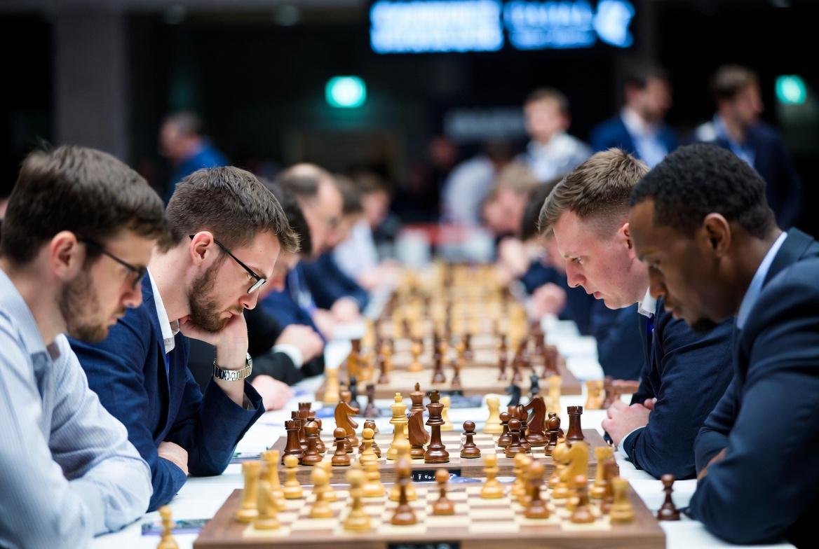 "Intense chess grandmasters strategic battle on grand stage, tension and focus atmosphere."