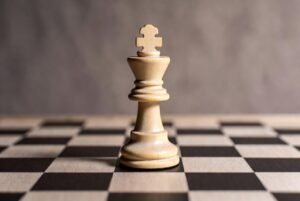 Alt text: Intense chess match culminates in victorious checkmate within dimly lit room.